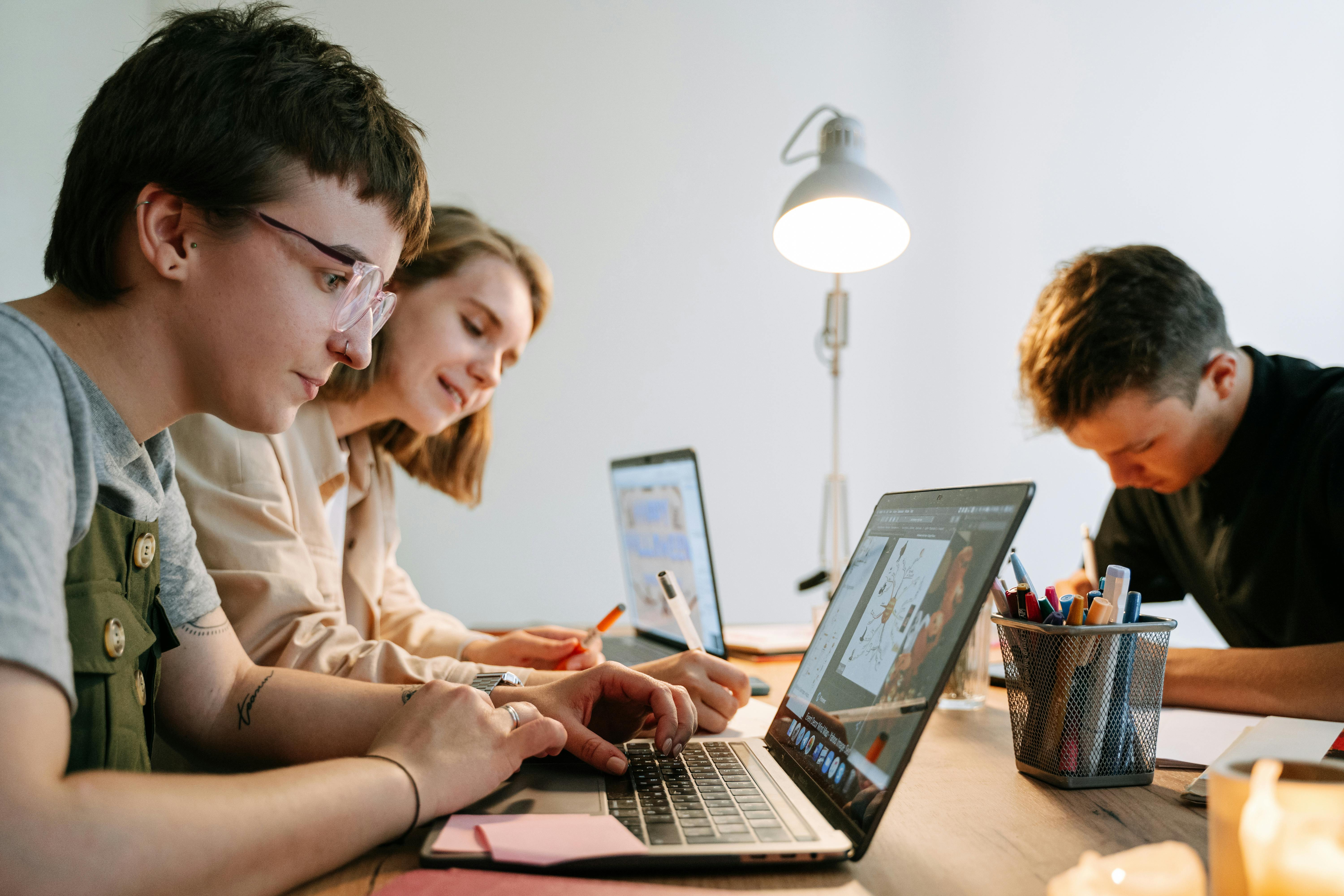 Young people working together at their laptops